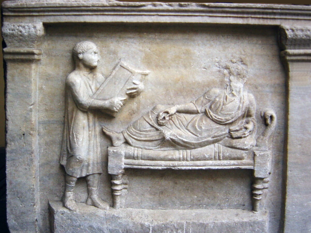 Relief of a sarcophagus showing a slave or freedman with writing tablets.