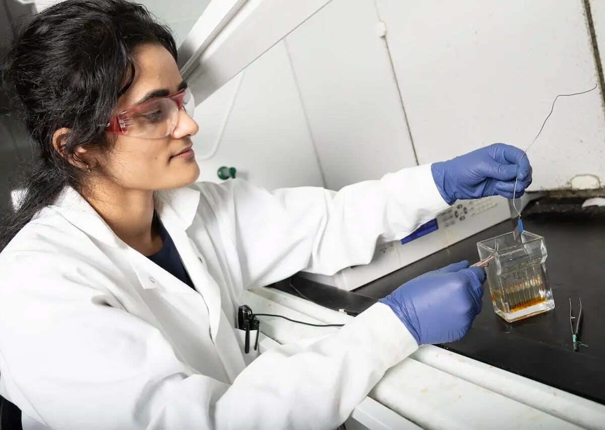 La becaria posdoctoral Anuja Tripathi examina una pequeña muestra de acero inoxidable tras un proceso de grabado electroquímico diseñado por ella para crear estructuras en forma de aguja a escala nanométrica en su superficie. Un segundo proceso deposita iones de cobre en la superficie para crear un material antibacteriano dual