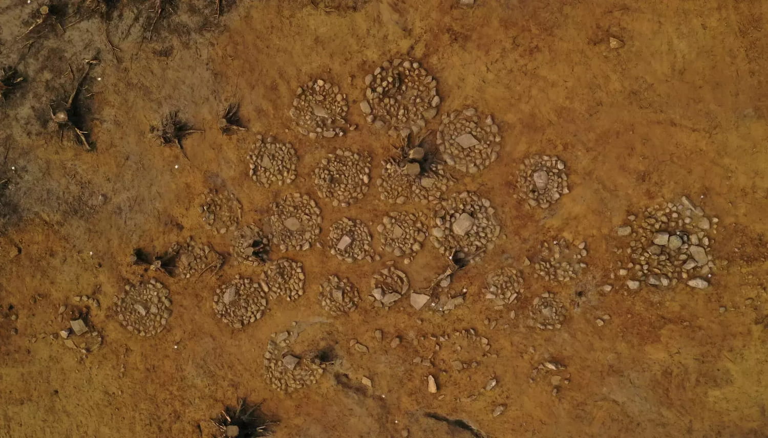 La imagen de un dron capta varias de las tumbas desde arriba. Los círculos, bastante similares, tienen entre uno y dos metros de diámetro.