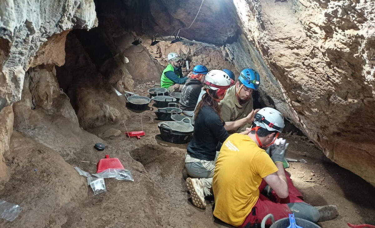 Miembros del GAAM realizando trabajos de excavación en la cova de l'Home Mort.